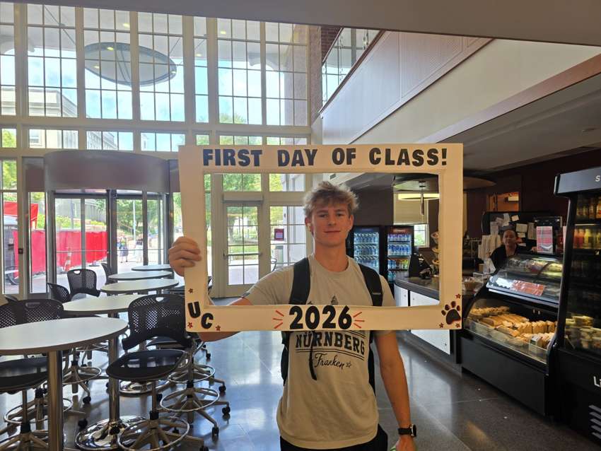 Sean holding a first day of class frame at UC in 2026